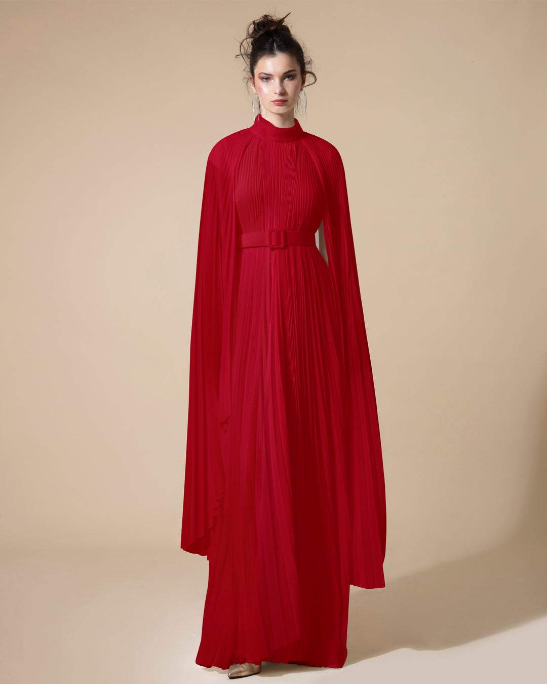 A fully pleated flared chiffon red kaftan dress with cape-like asymmetrical sleeves paired with a matching detachable belt.