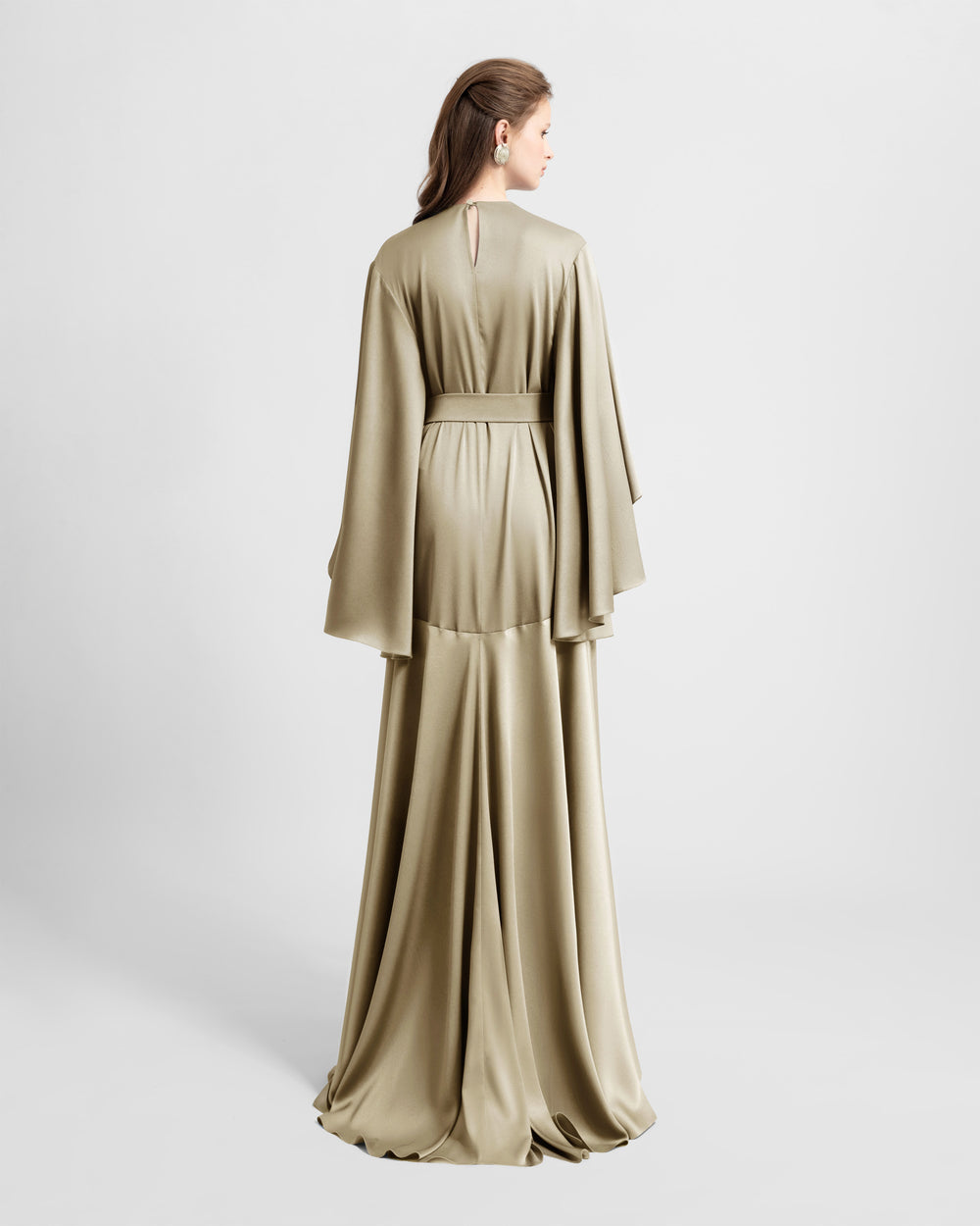 The back of a loose-cut satin greige evening dress featuring bell sleeves cut and a detachable belt.