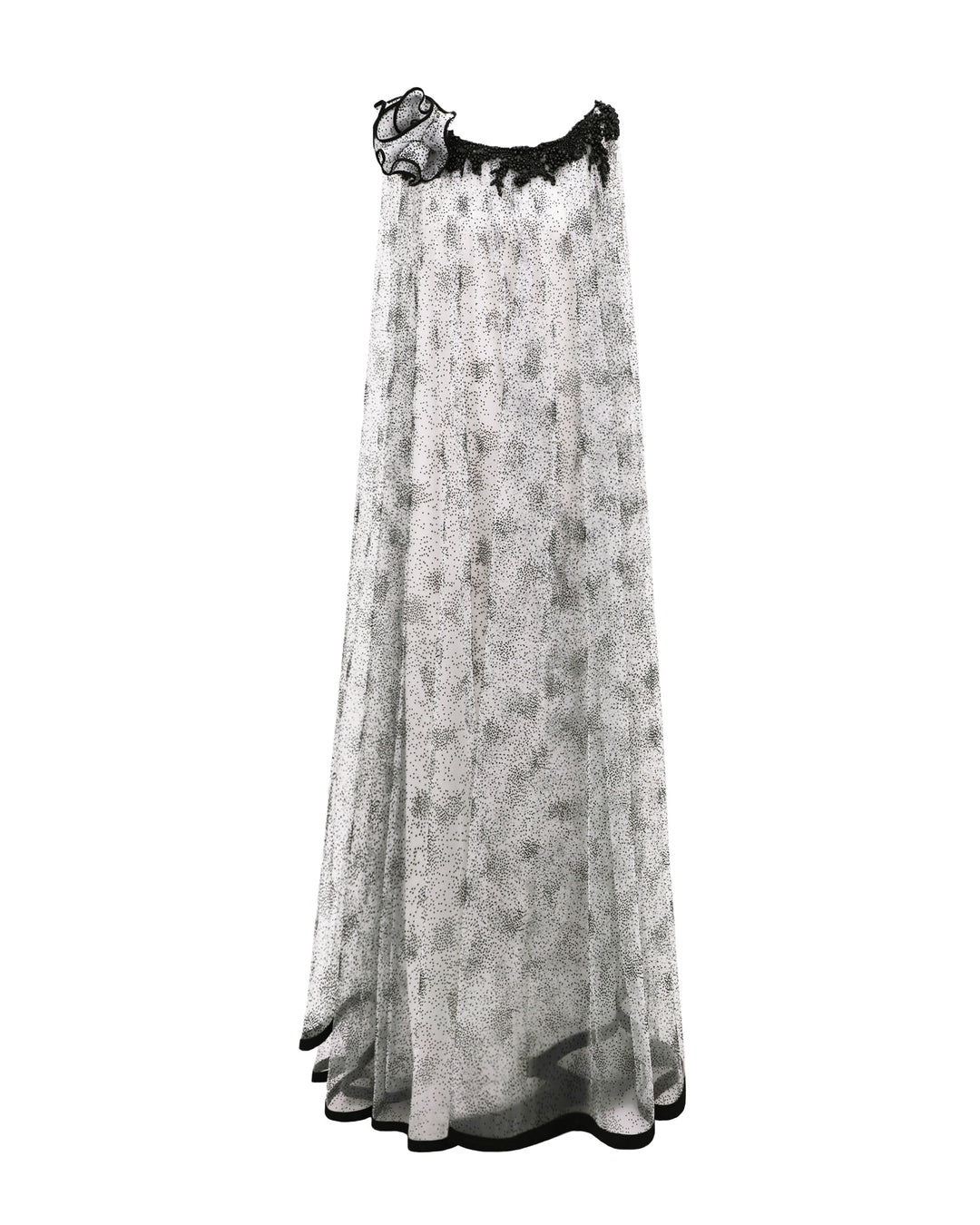 A loose-cut kaftan-style black dotted white tulle dress featuring beadings on the neckline, a draped flower on the shoulder, and a black hemline.