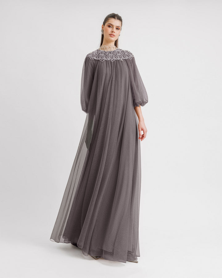 A kaftan-style loose-cut grey evening dress with lace at the neckline and three-quarter bishop sleeves.