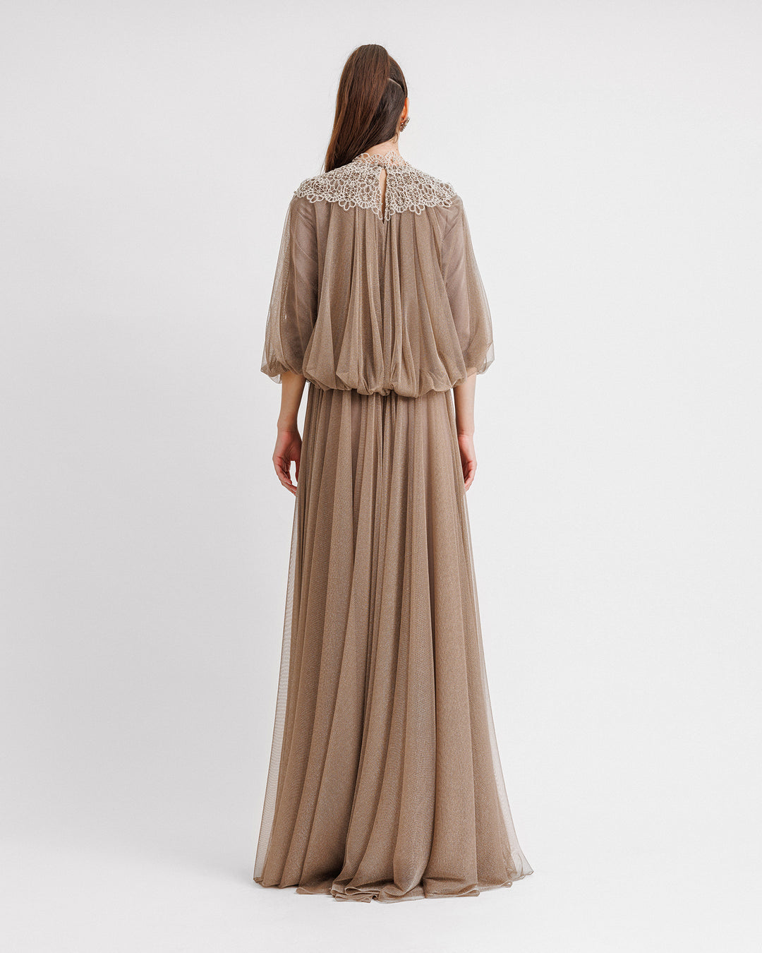 The back of a taupe color kaftan-style loose-cut tulle dress with lace at the neckline, gathered waist at the back, and three-quarter sleeves.