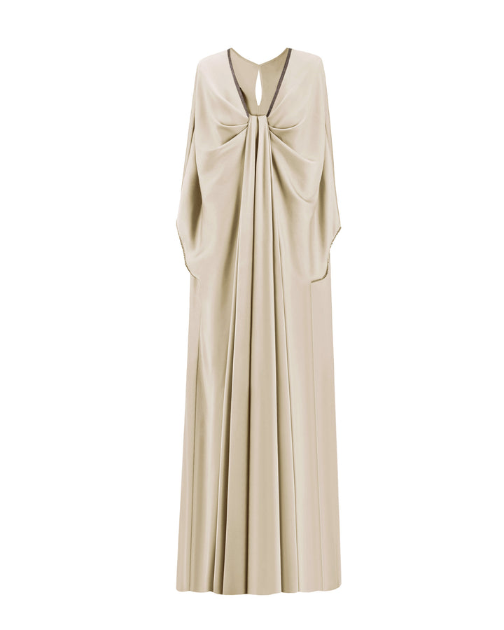 A cream satin kaftan-style evening dress with a draped beaded neckline, featuring three-quarters sleeves with beaded cuffs.