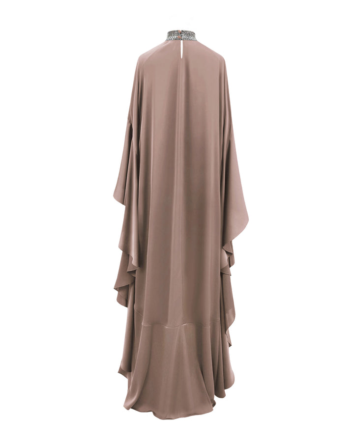 The back of a kaftan-style evening dress in taupe color with a beaded collar and ruffled floor-length sleeves.