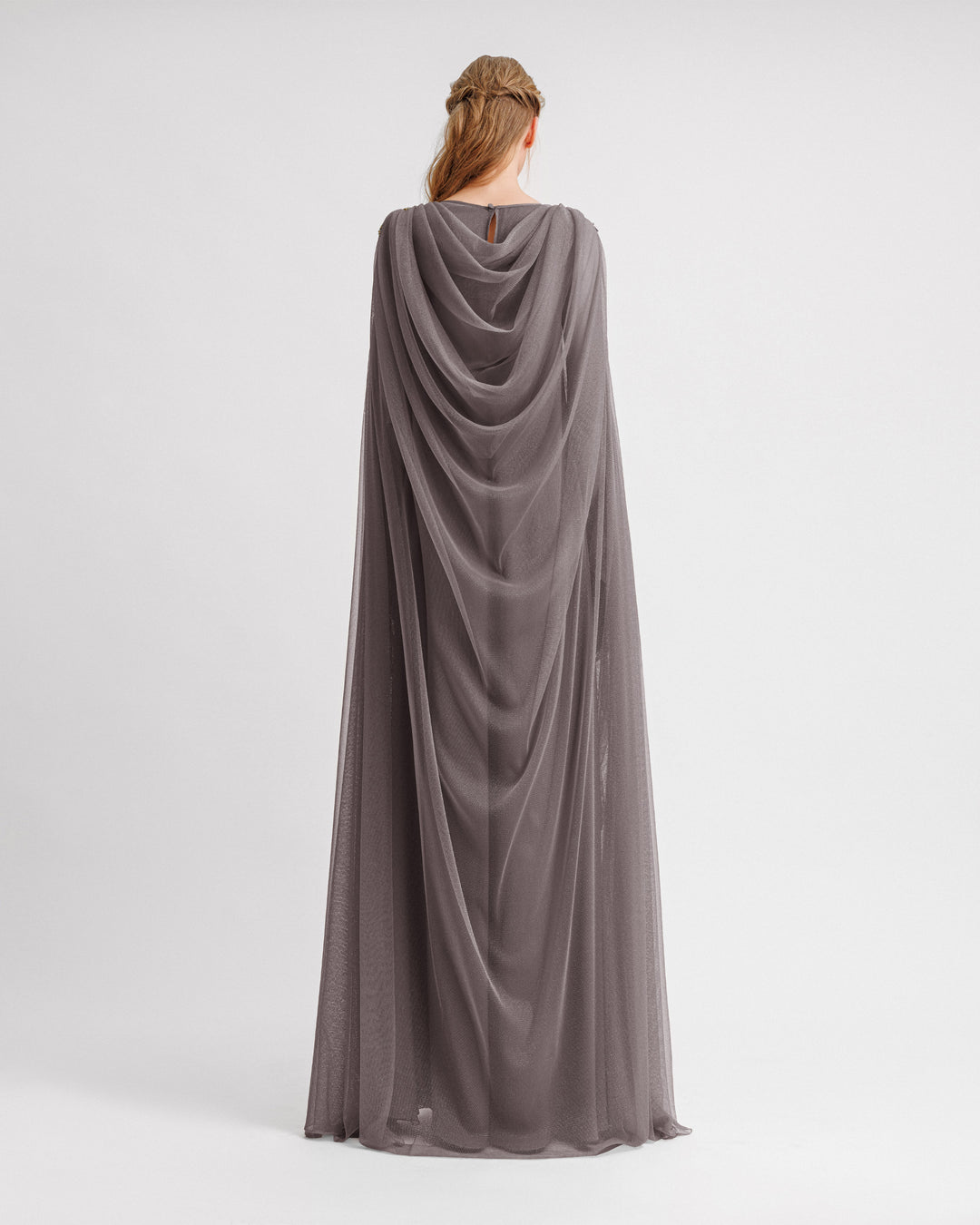 The back of a loose-cut kaftan grey evening dress with floor length cape like sleeves and draping on the back.