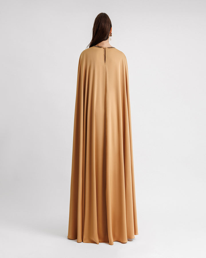 The back of a caramel color kaftan-style evening dress with a beaded neckline.