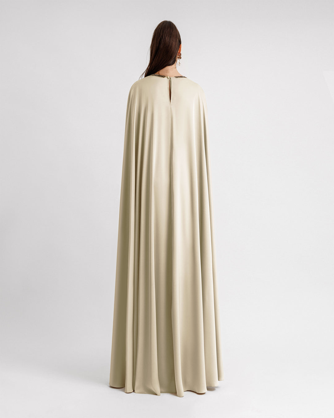 The back of a cream color satin Kaftan-style evening dress with a beaded neckline.