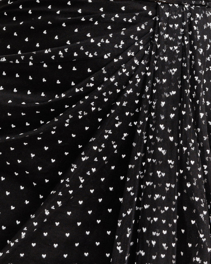 A close up of a black tulle draping detail with mini white heart pattern.