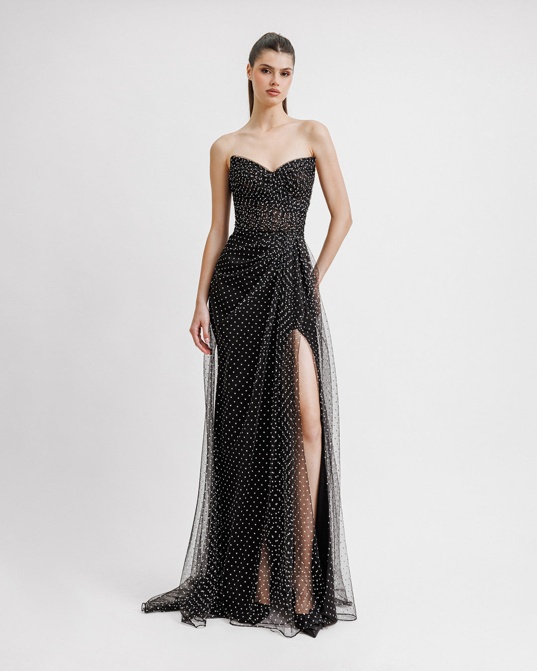 A strapless heart-neckline draped black dress with a slit on the side and mini white heart pattern.