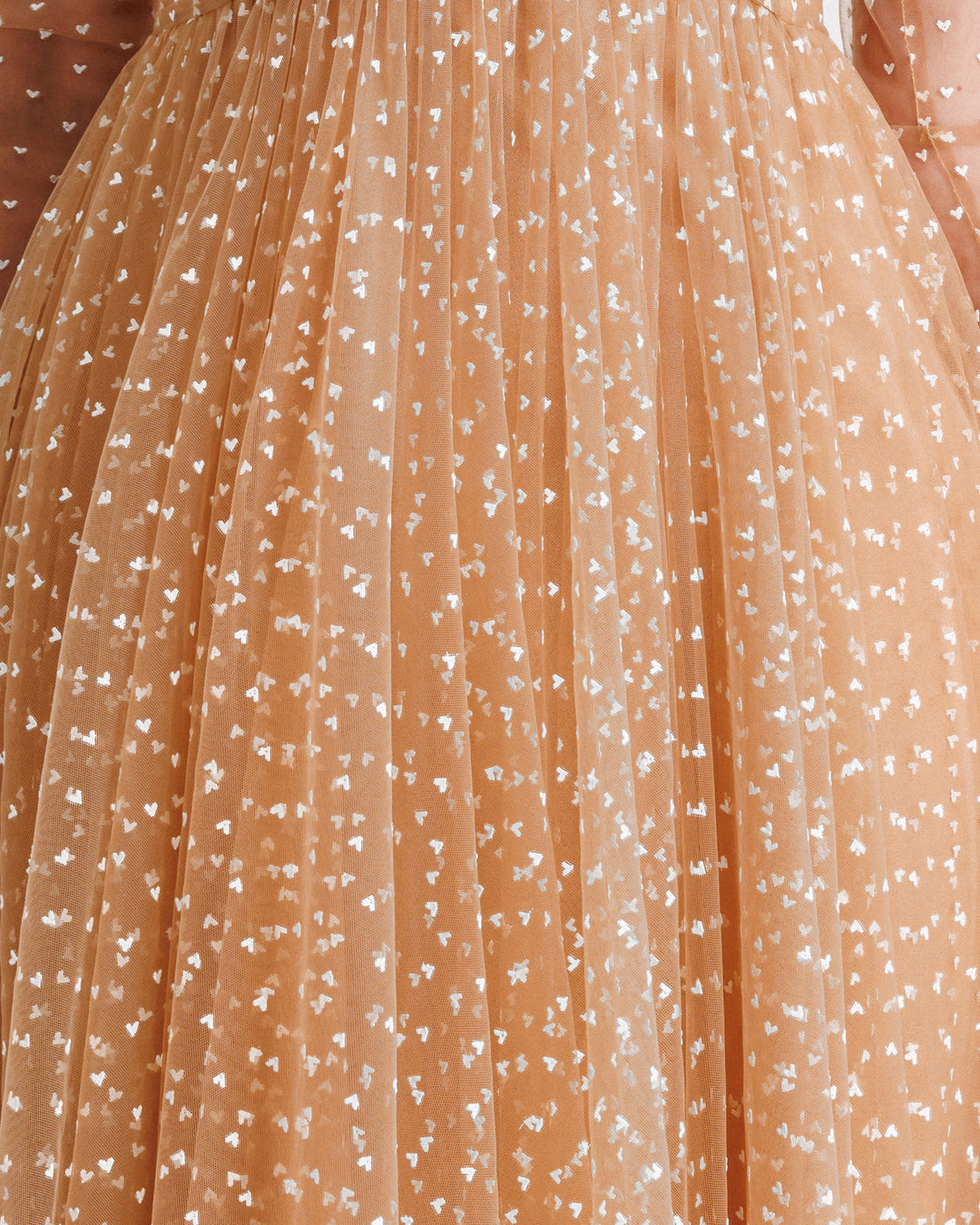 A close-up of white heart pattern caramel tulle.