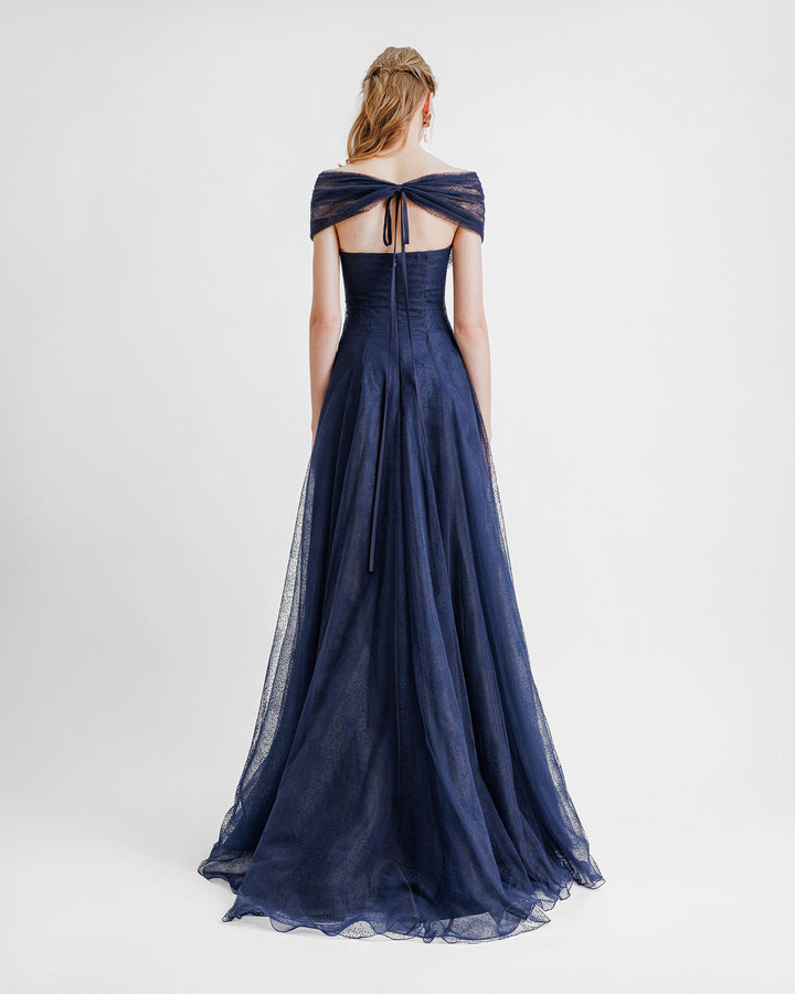 A draped off-the-shoulders navy dress with a gathered bow closure at the back.