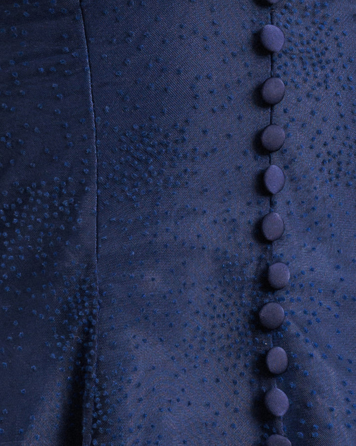 A close up of a navy dotted fabric with buttons.