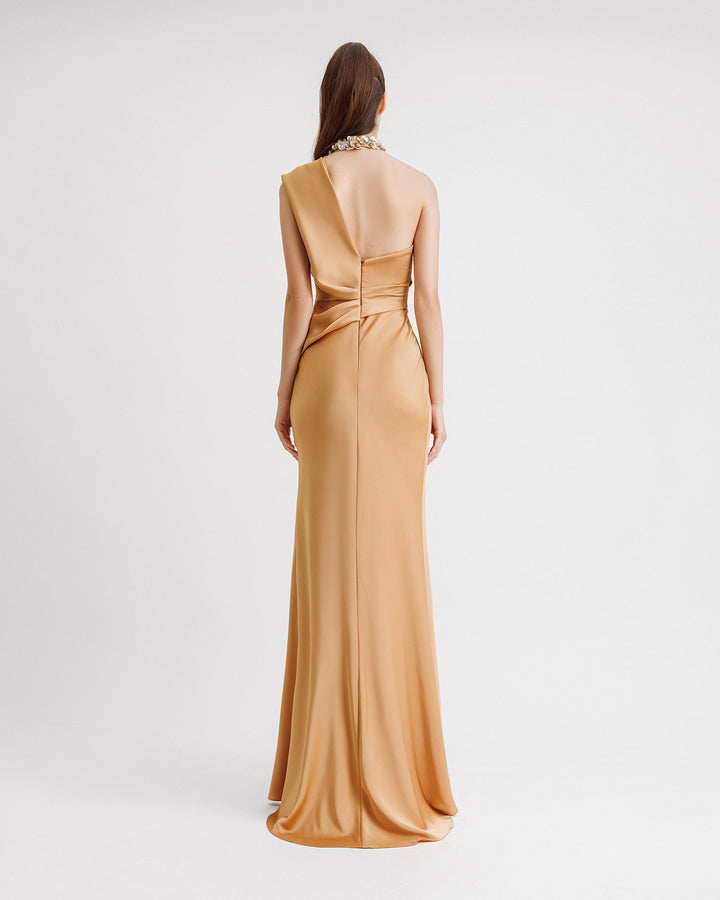 The back of  a one-shoulder draped evening dress in caramel color satin with floral embellishments on the neckline.