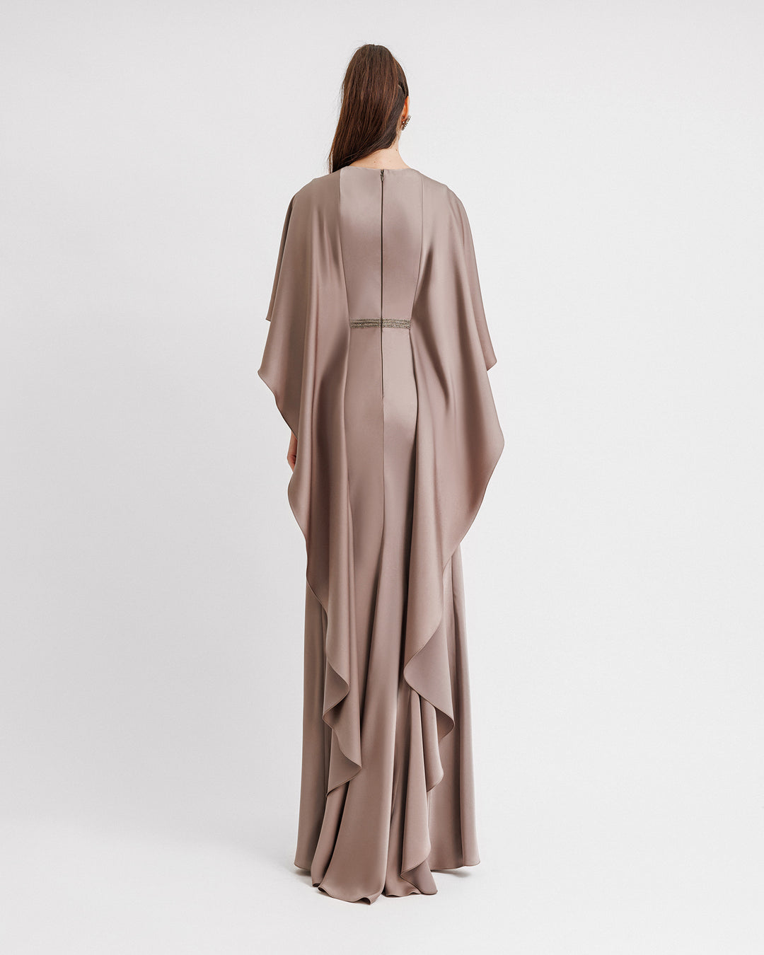 The back of a draped satin evening dress in taupe color with ruffled cape-like sleeves.