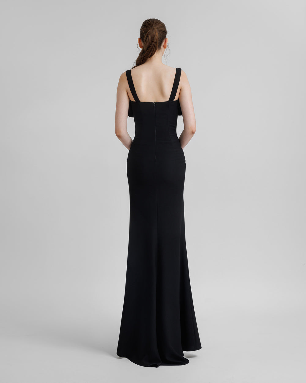 The back of a slim-cut black long evening dress.