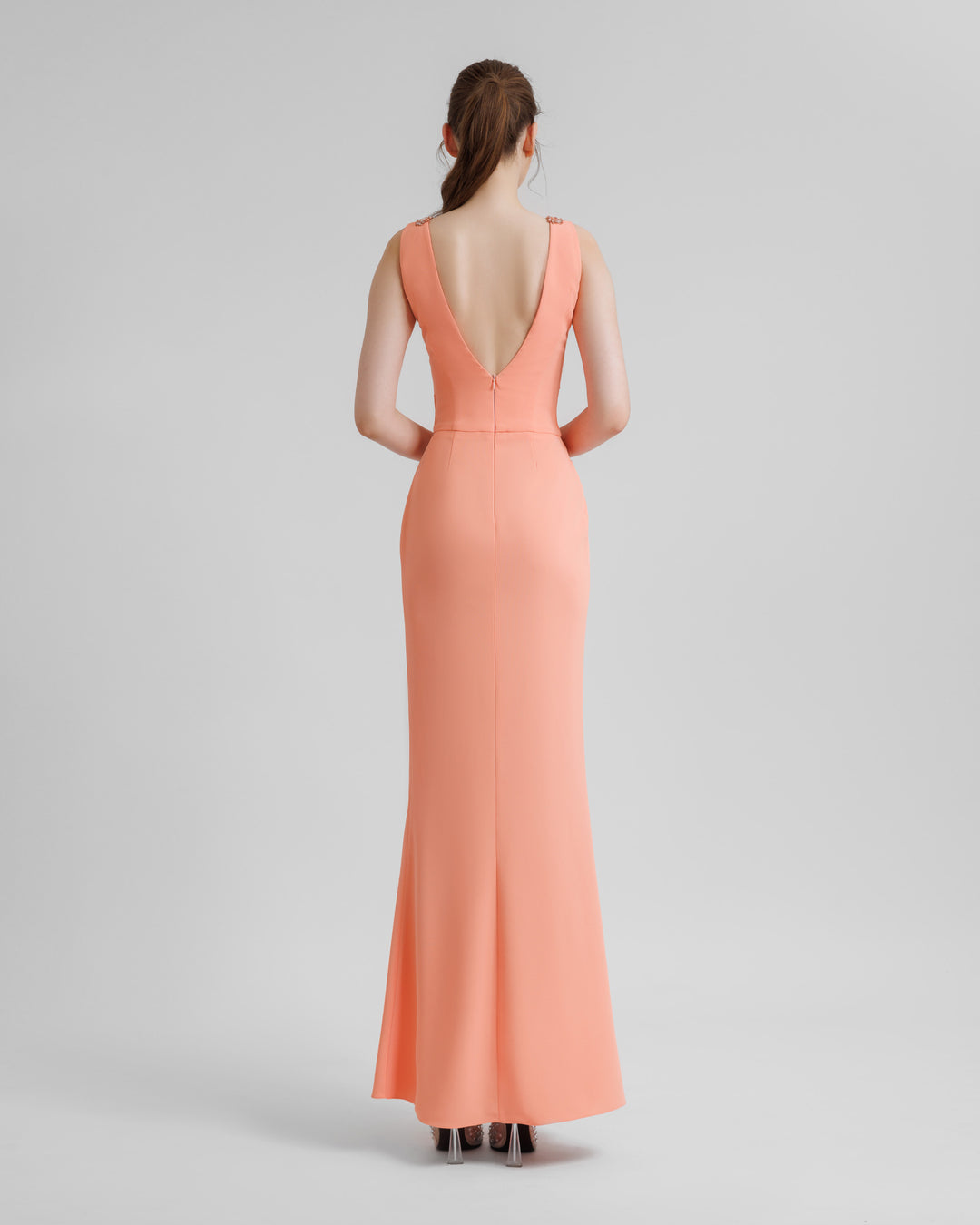 A V-shaped open back peach evening dress. 