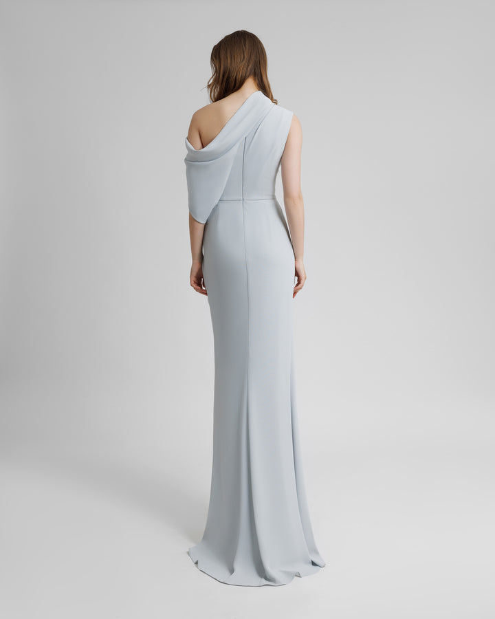 The back of an asymmetrical off shoulders neckline long dress with draping details and a high slit on the side.