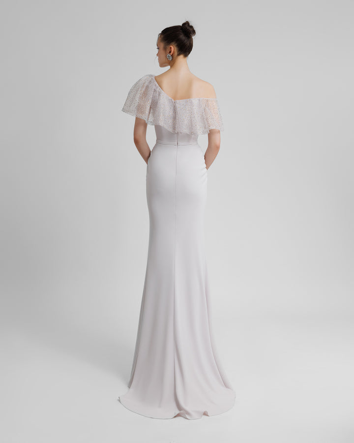 The back of an asymmetrical beaded mesh ruffled neckline slim-cut long evening dress in light lilac color.