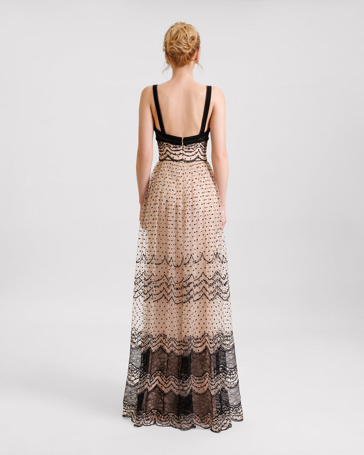 The back of a black and beige evening dress with a defined embroidered waistline.