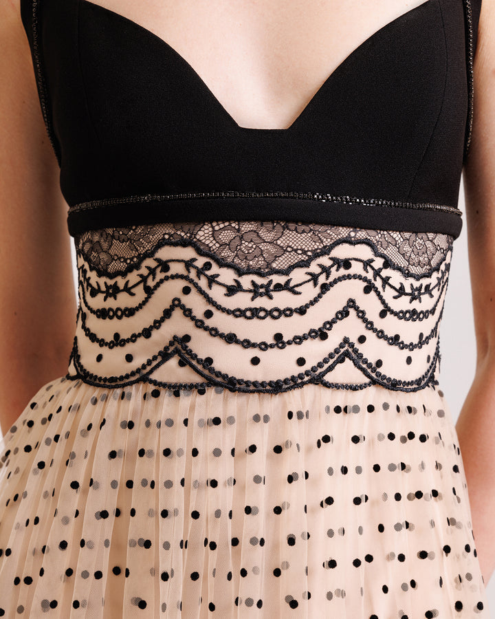 A close-up of a heart-neckline black and beige evening dress with a defined embroidered waistline.