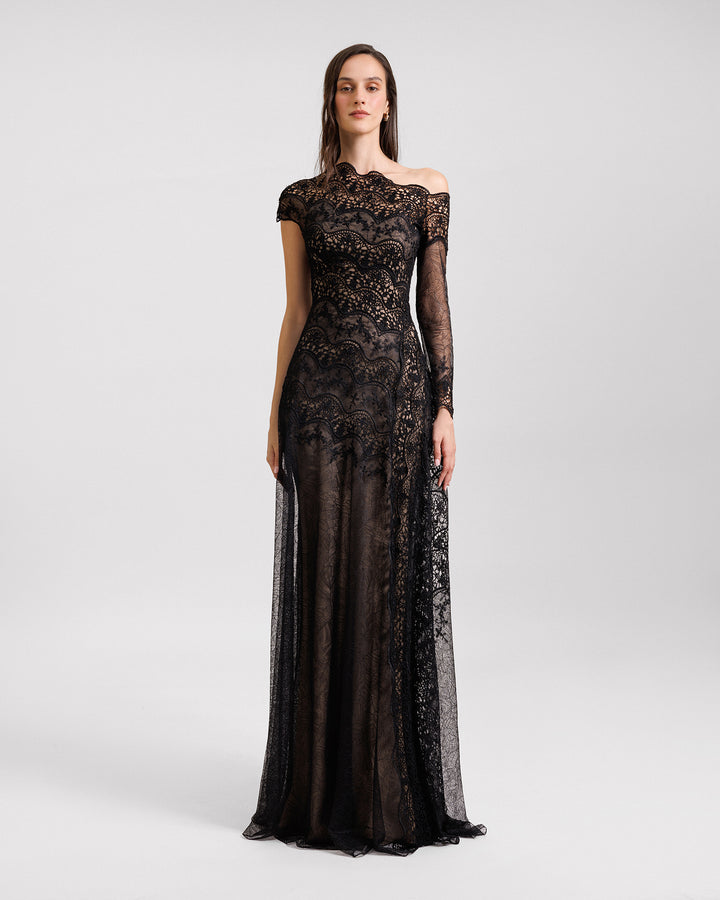 An asymmetrical neckline black evening dress in embroidered lace featuring a one long sleeve.