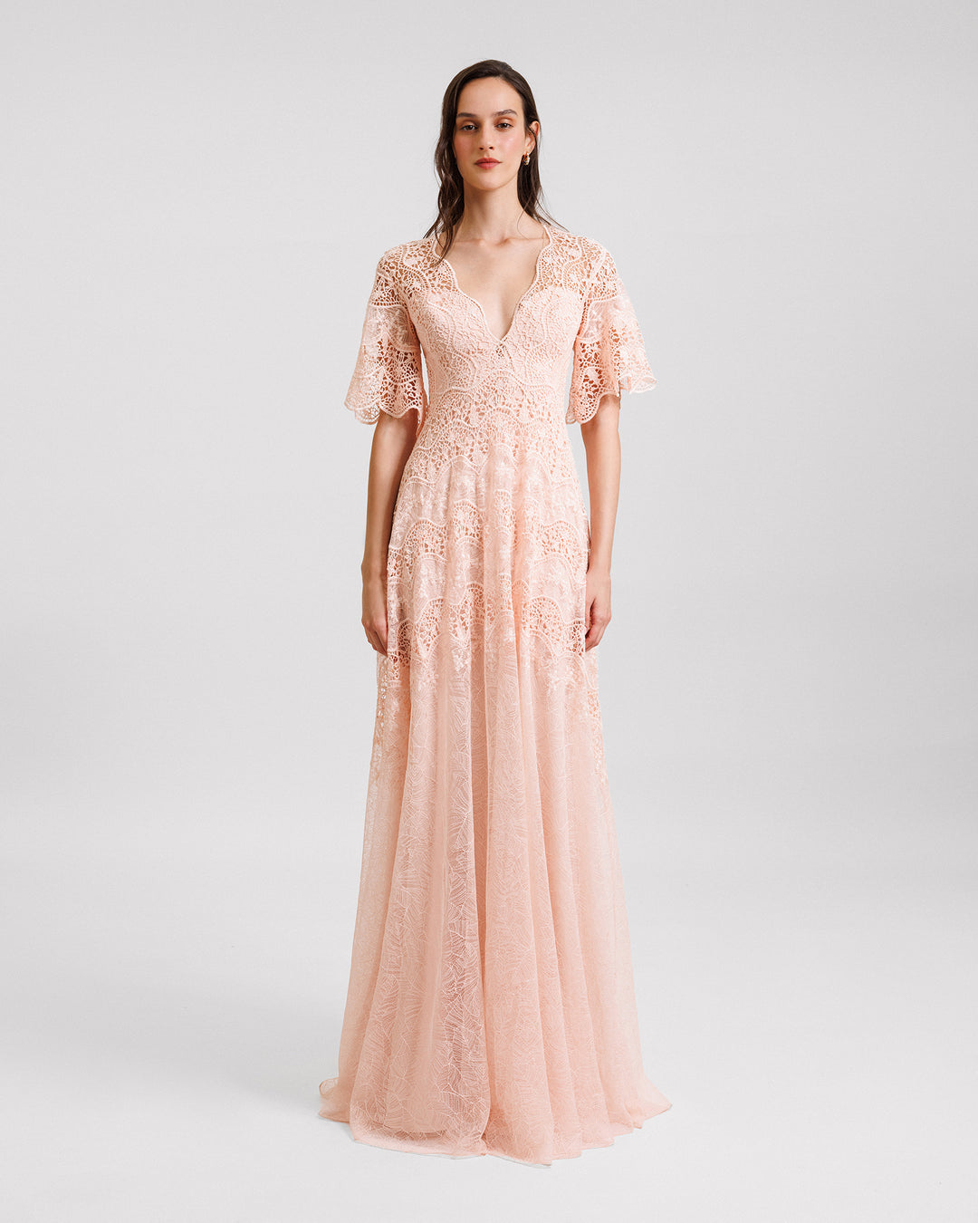 A V-neckline lace evening dress in peach color with short bell sleeves.