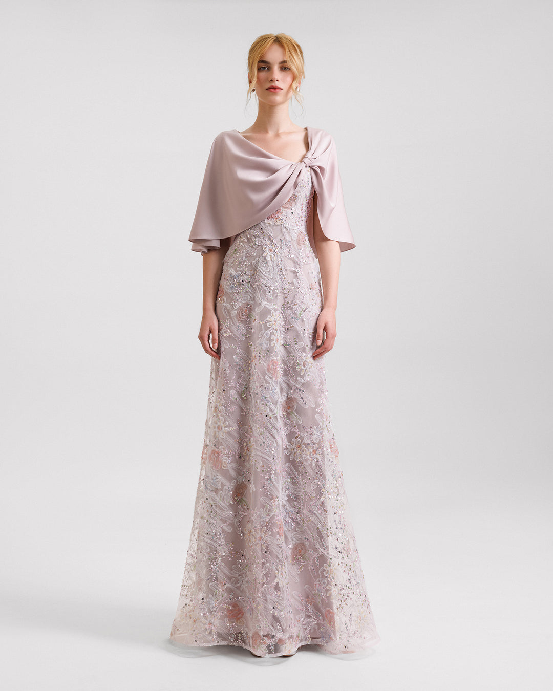 A beaded embroidery evening dress in dusty pink with asymmetrical cape-like sleeves.