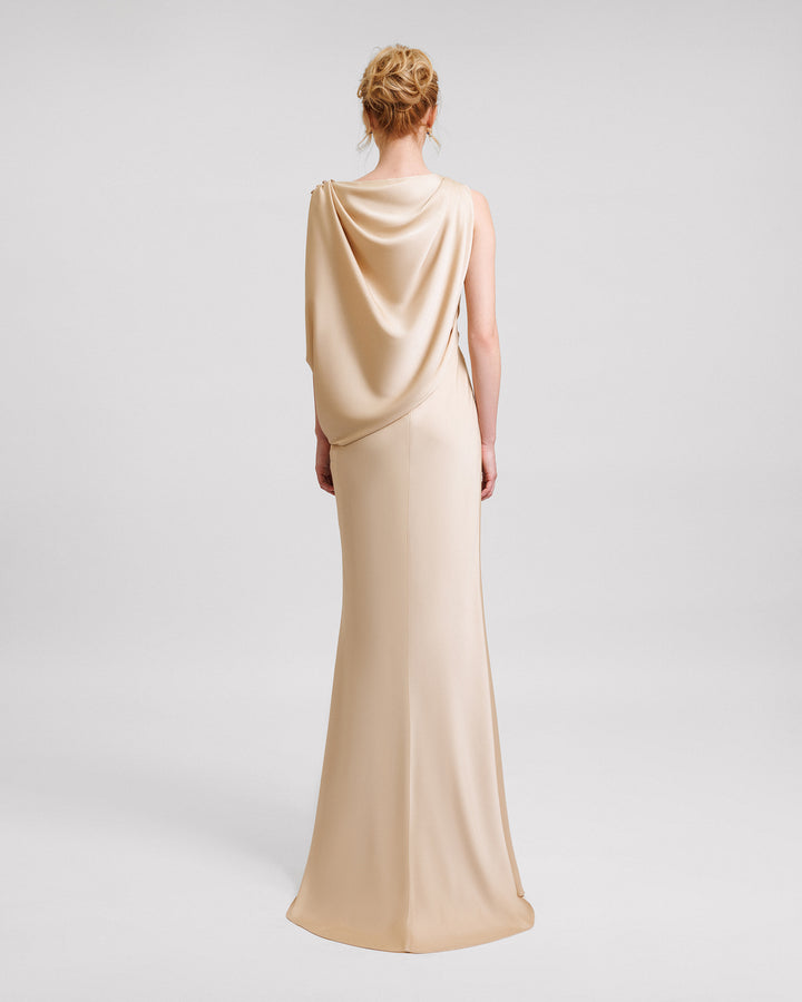 The back of an asymmetrical draped evening dress in champagne satin fabric.