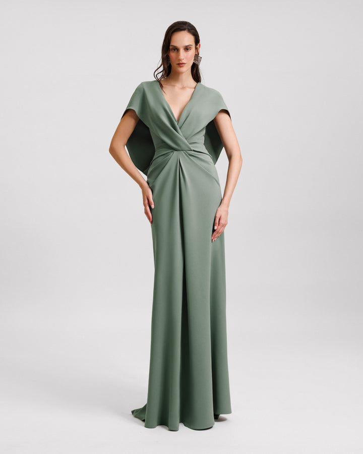 A v-neckline draped evening dress in sage color with cape-like sleeves.