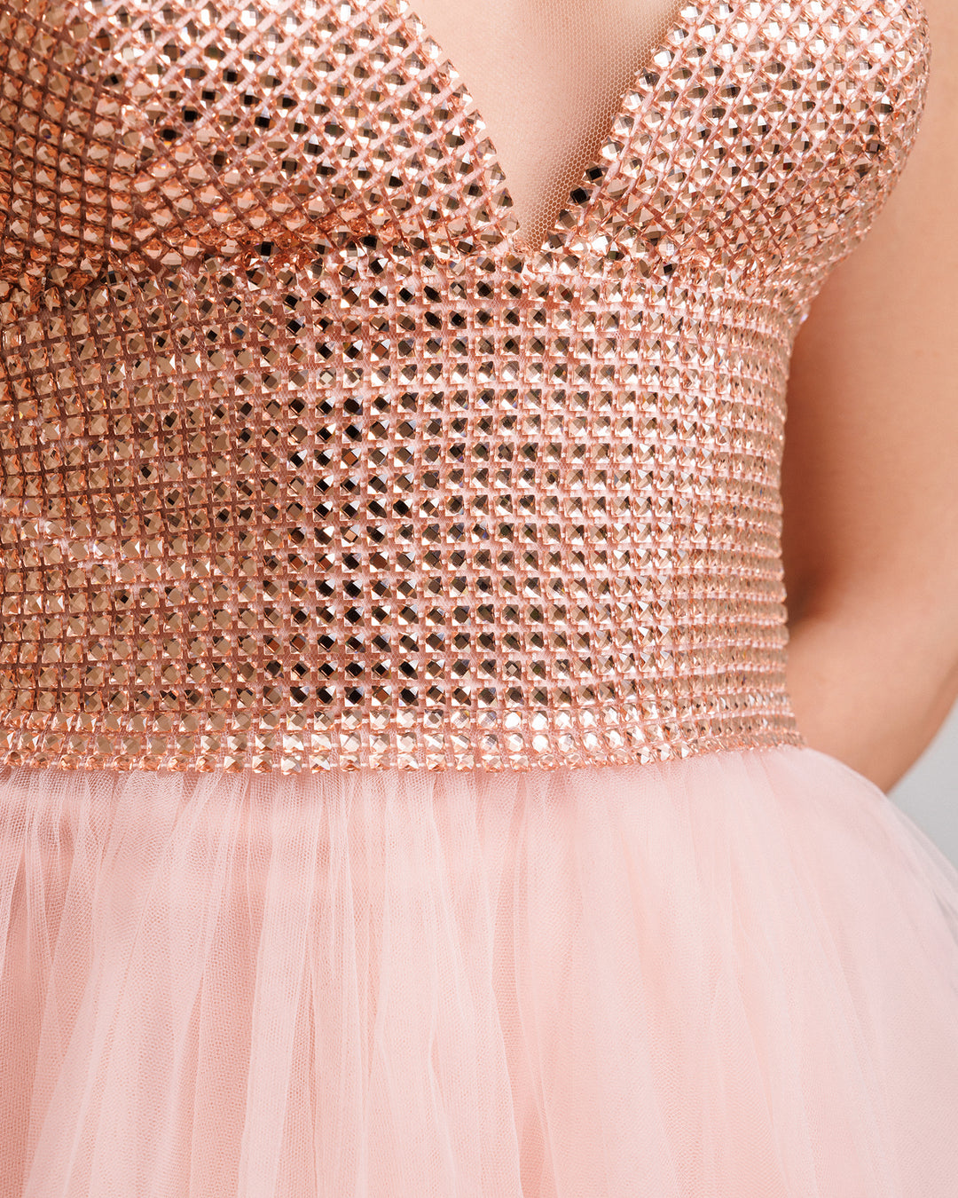 A close-up of a v-neckline evening dress with a stone embellished corset and a tulle skirt.