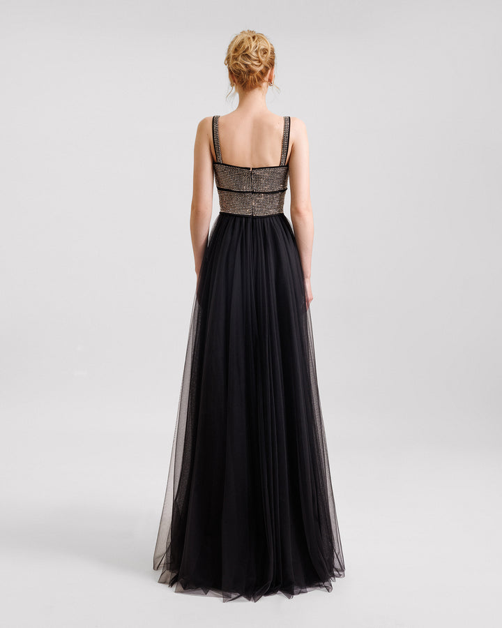 The back of a long black evening dress in tulle with a stone embellished bodice.