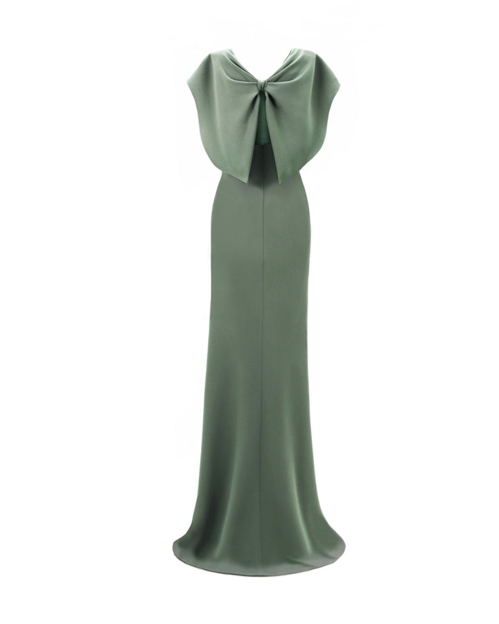 The back of a draped evening dress in sage color with cape-like sleeves and a bow design at the back.