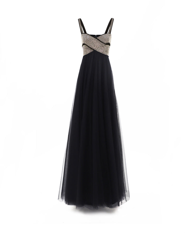 A long black evening dress in tulle with a bow-like stone embellished top.