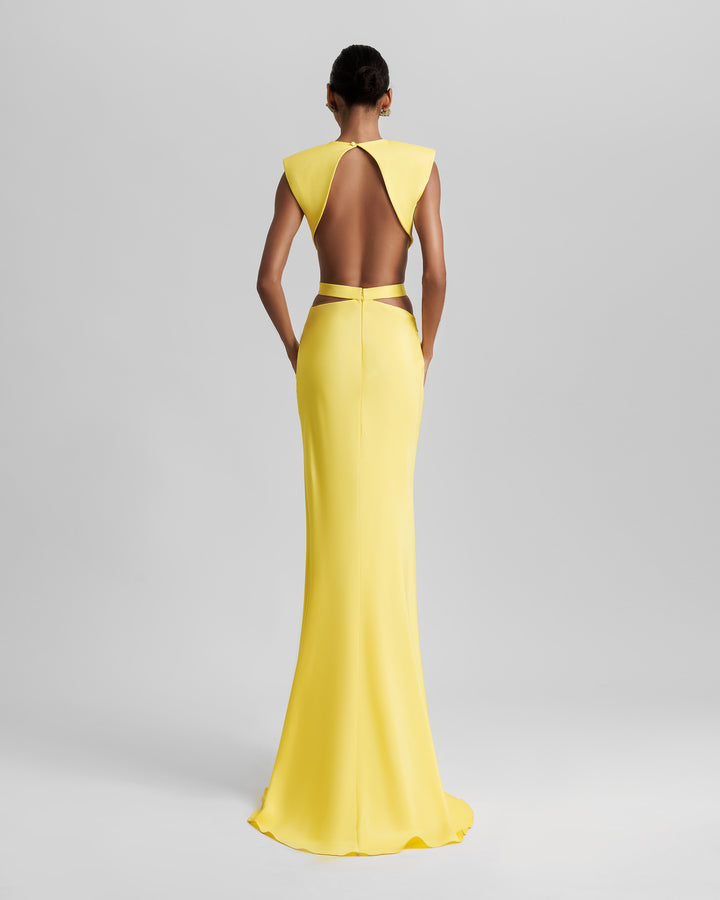 The back of a slim-cut yellow dress featuring padded shoulders, cut-outs on the waist, and an open back.