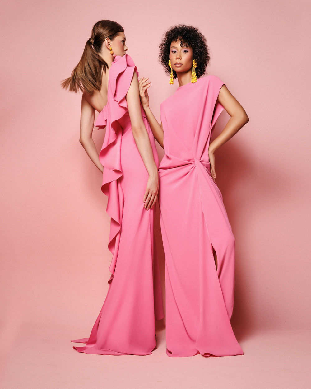 A one-shoulder pink evening dress with draping on the waist, and a ruffled neckline that goes all the way to the back, to end with a open slit.