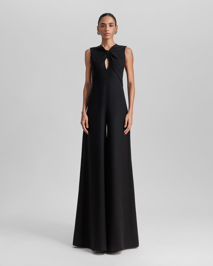 A black jumpsuit featuring pockets, a cut-out and a bow design at the front.