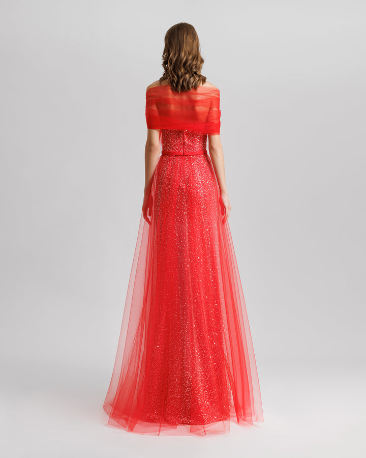 The back of an off-the-shoulders red tulle dress with a beaded underlayer.