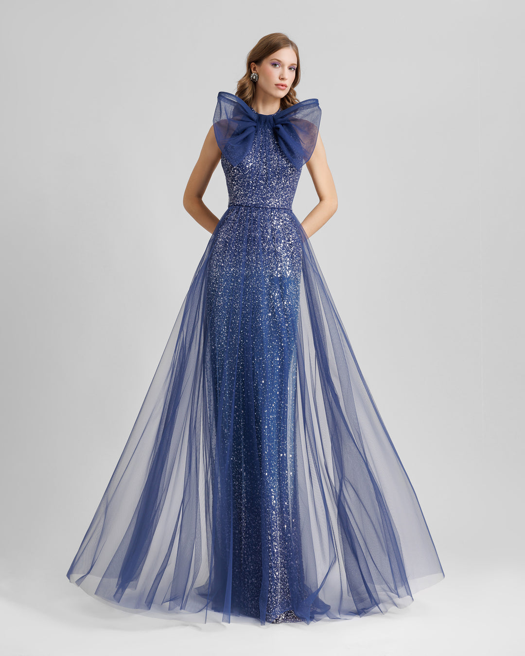 An halter-neck blue dress with a bow design and a beaded underlayer.