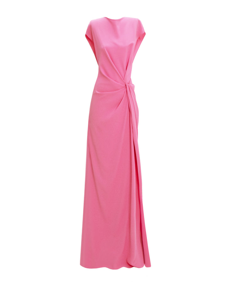 A loose-cut pink evening dress with draping at the waist and a slit on the side.