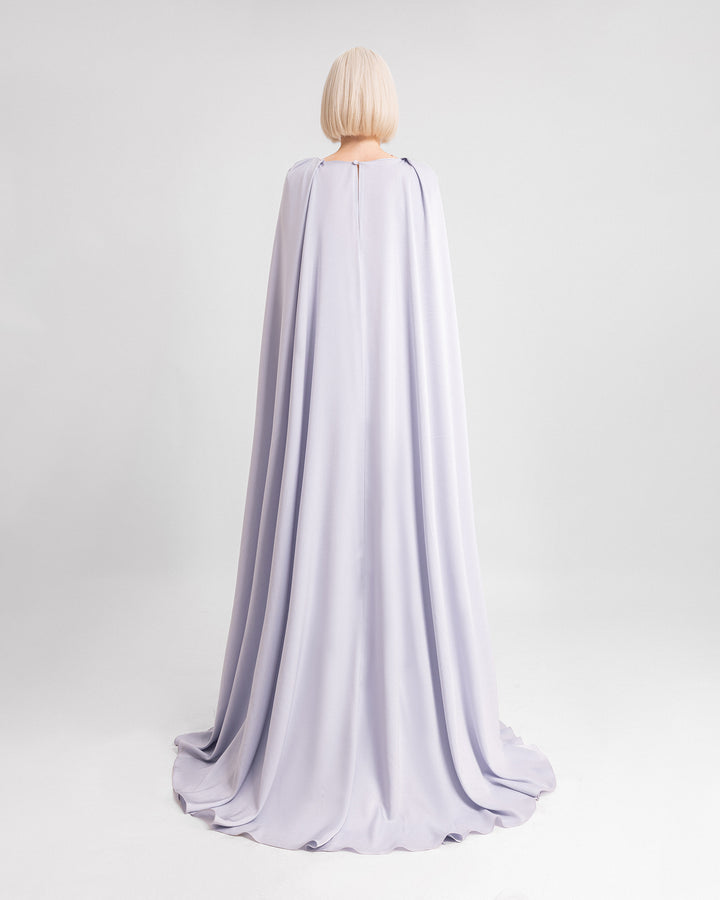 The back of a draped evening dress in ice blue satin fabric with a cape at the back.