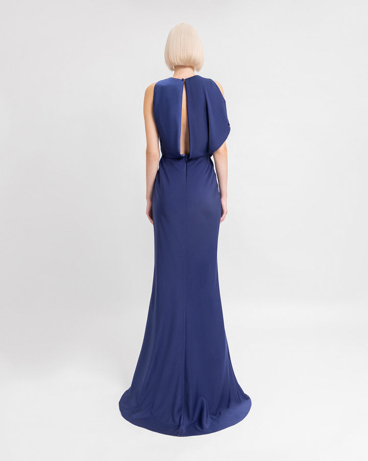 The back of a draped navy blue evening dress featuring a back cut-out and asymmetrical sleeves.