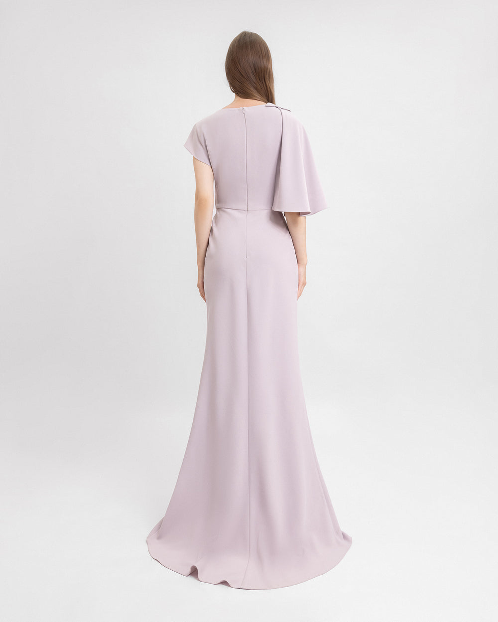 The back of a draped evening dress in dusty pink featuring asymmetrical sleeves.