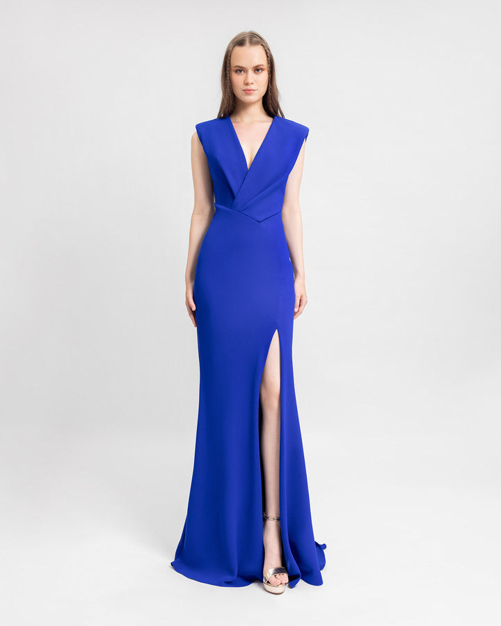 A v-neckline draped evening dress with an open slit on the side and an asymmetrical waistline.