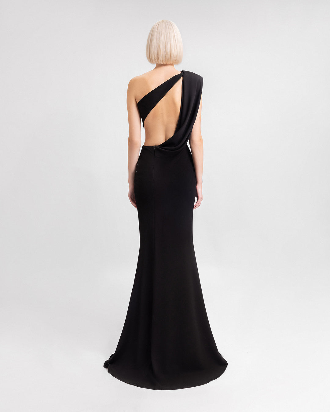 The back of a one-shoulder black evening dress with a cut-out at the back.