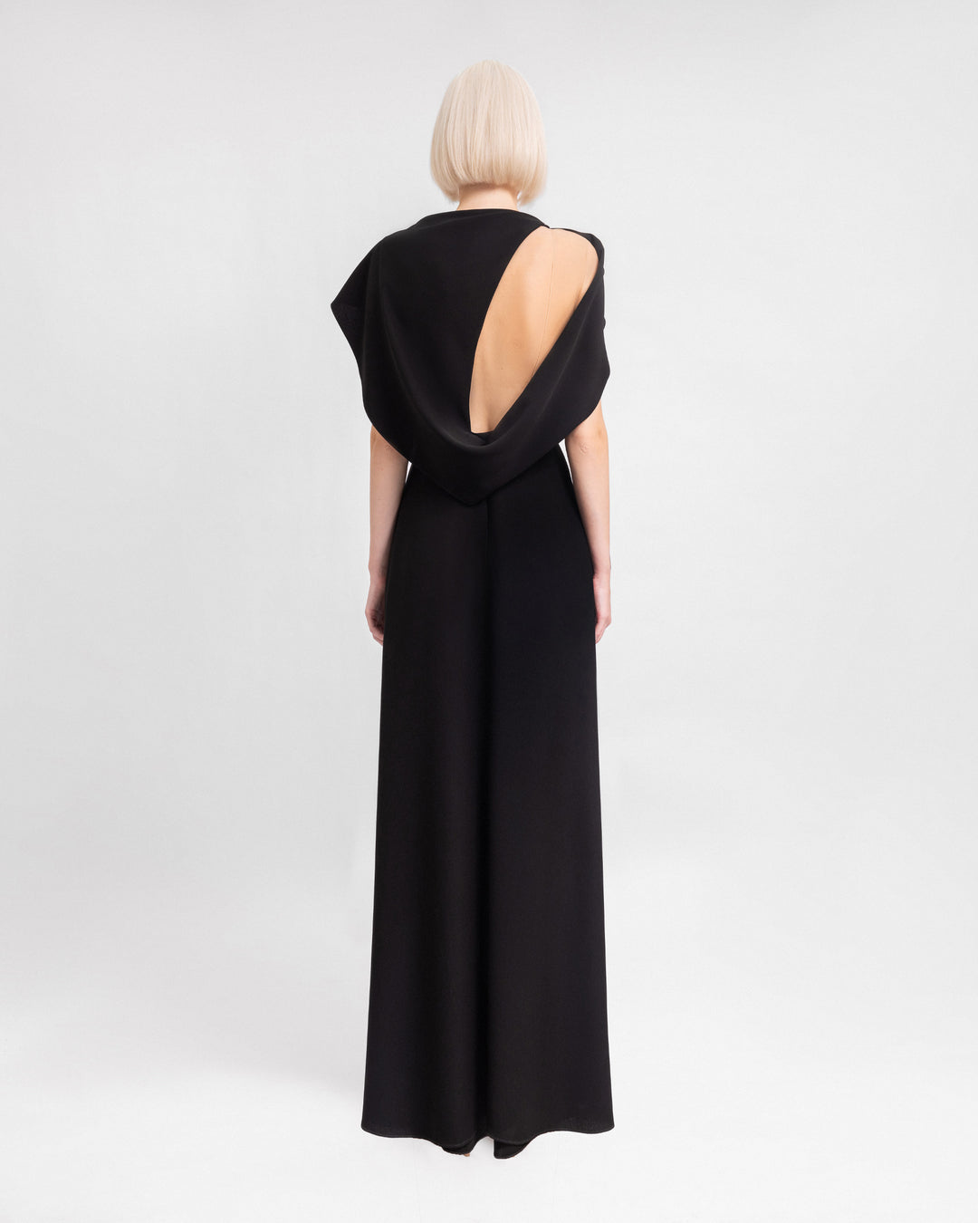 The back of a long evening dress with draped sleeves and a cut-out at the back.