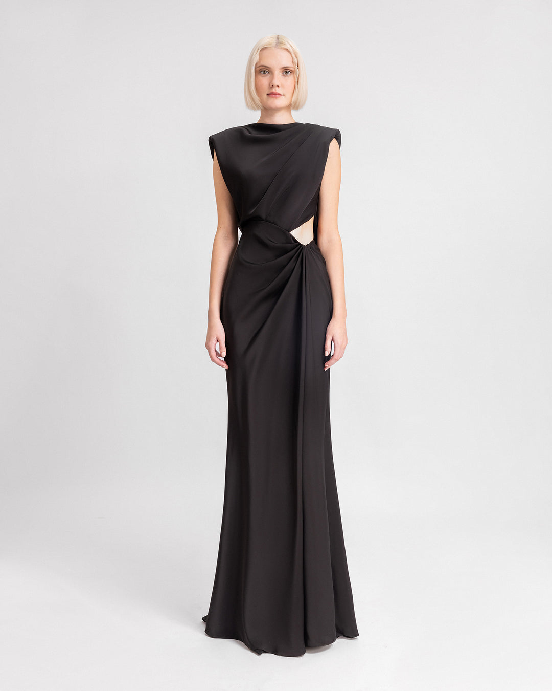 A long draped black k evening dress with a cut-out at the side and an open-back.