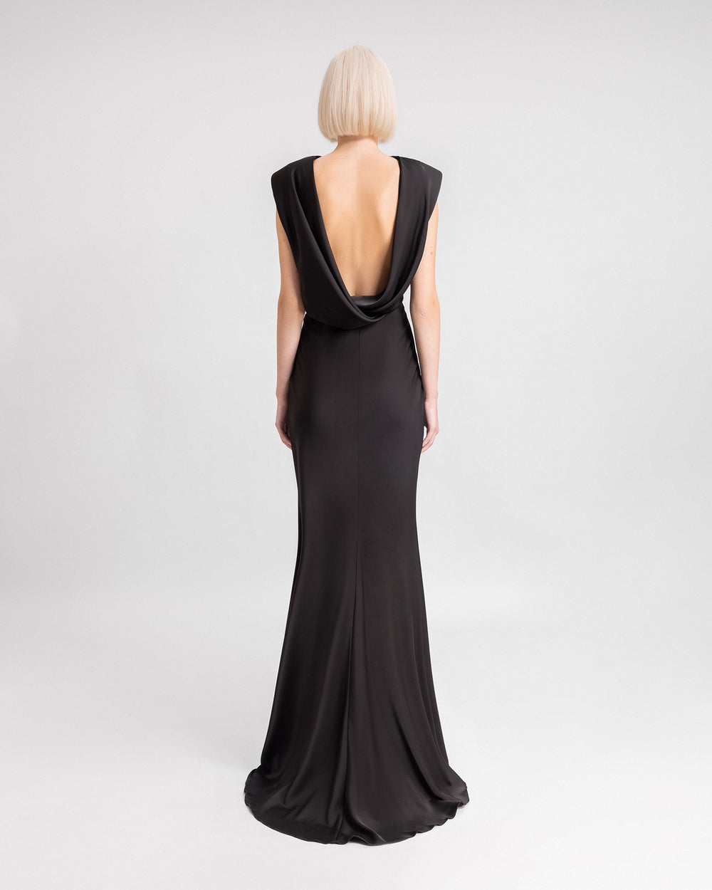 The back of a long black dress with a draped cowl open-back.