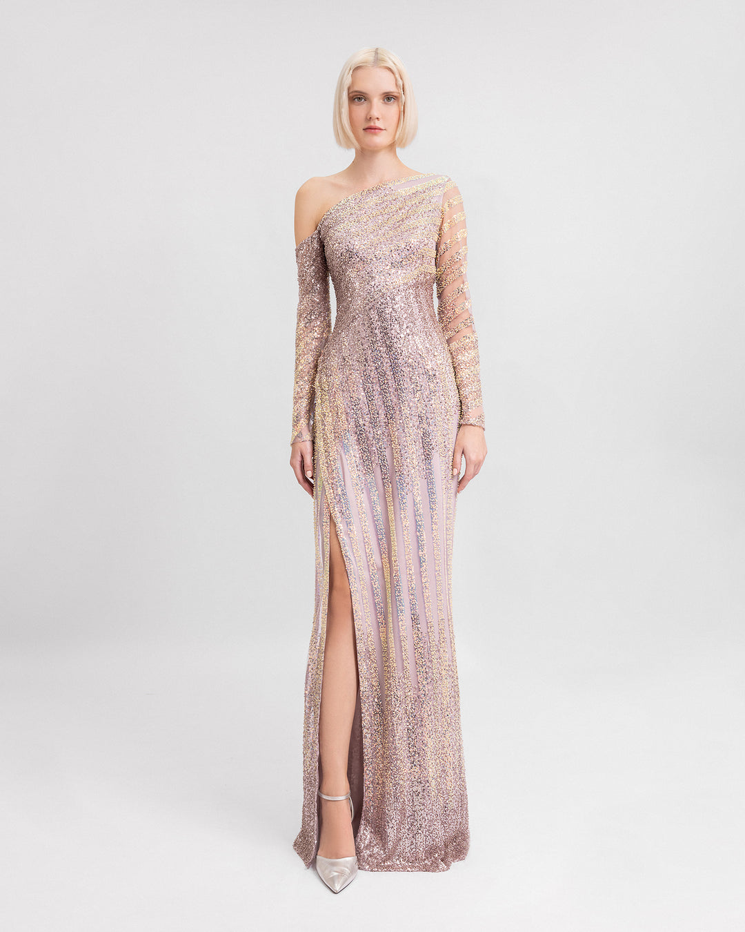 A fully beaded asymmetrical neckline evening dress with long sleeves and a slit on the side.