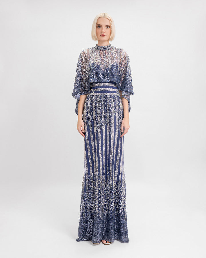 A long beaded sequins dress in navy hues with cape-like sleeves.