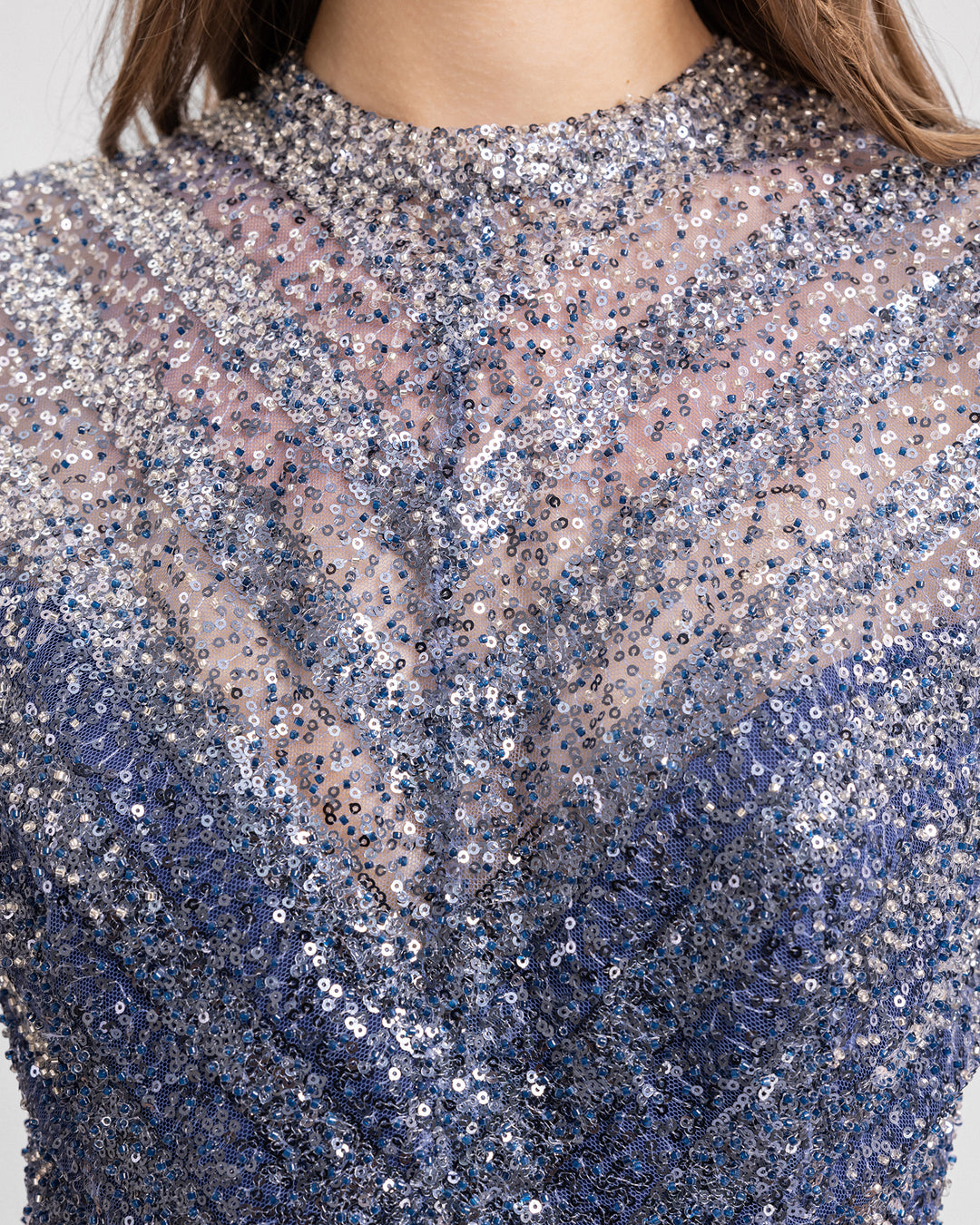 A close-up of a fully beaded evening dress in navy hues.