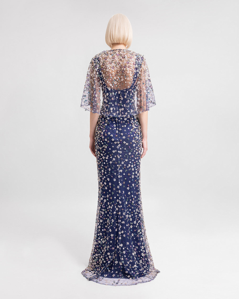 The back of a V-neckline fully beaded evening dress with cape-like sleeves and a see-through back.